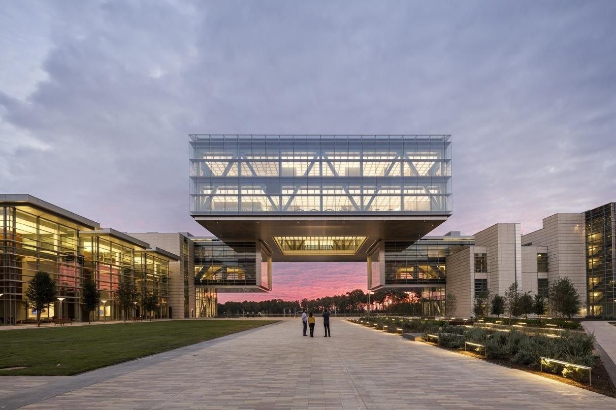 ExxonMobil: Lit cube building at dusk across a lawn