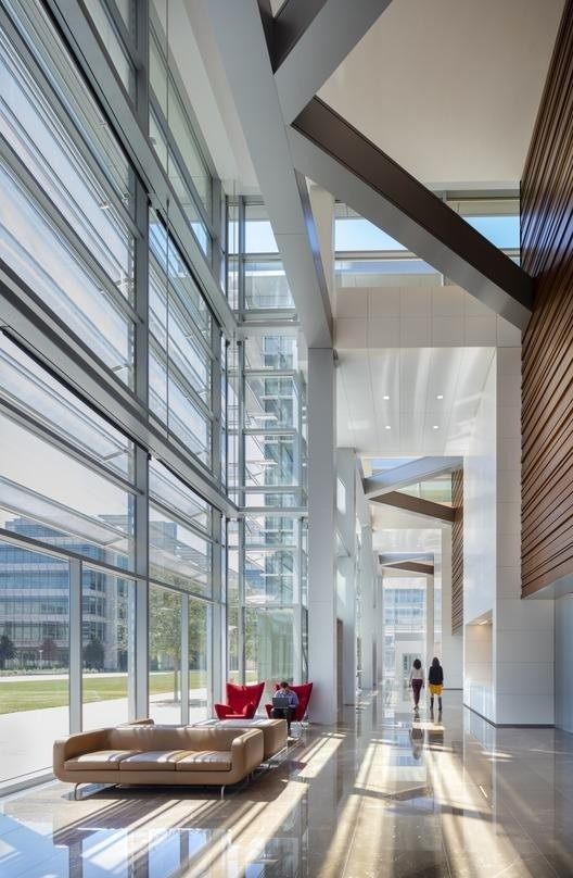 ExxonMobil: Tall glass hall with steel braces and red seating