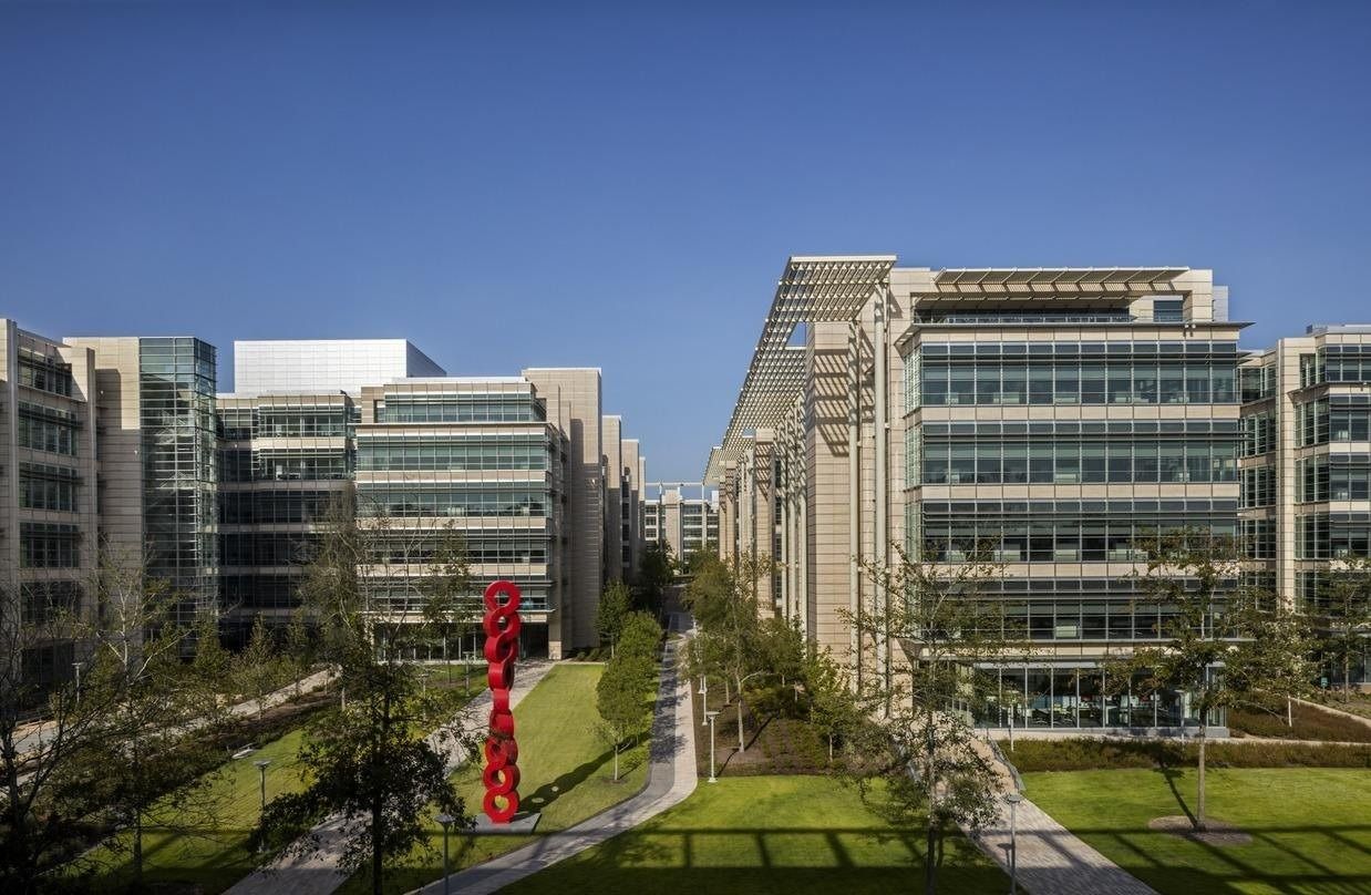 ExxonMobil: Tree-lined street between office buildings with a red sculpture