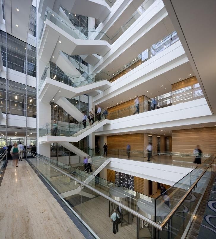 ExxonMobil: White stairs zigzagging through a tall atrium