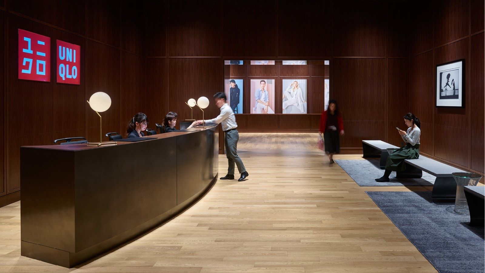 Fast Retailing (UNIQLO): Dark timber reception desk below the UNIQLO logo
