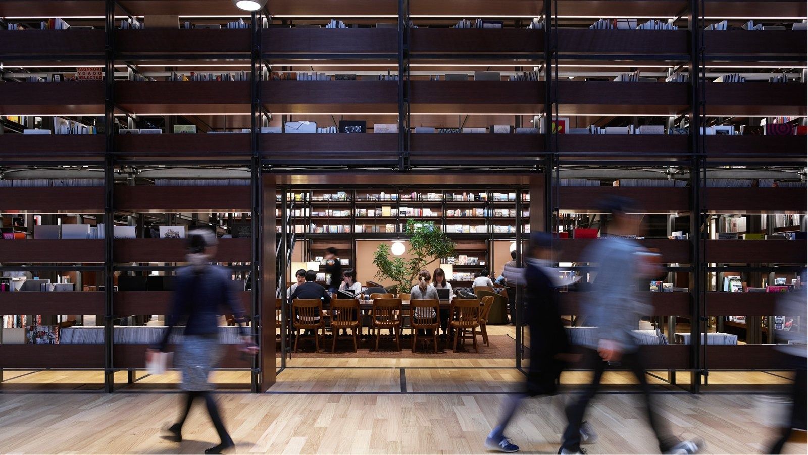 Fast Retailing (UNIQLO): Glass-fronted room with tall bookshelves seen from the street