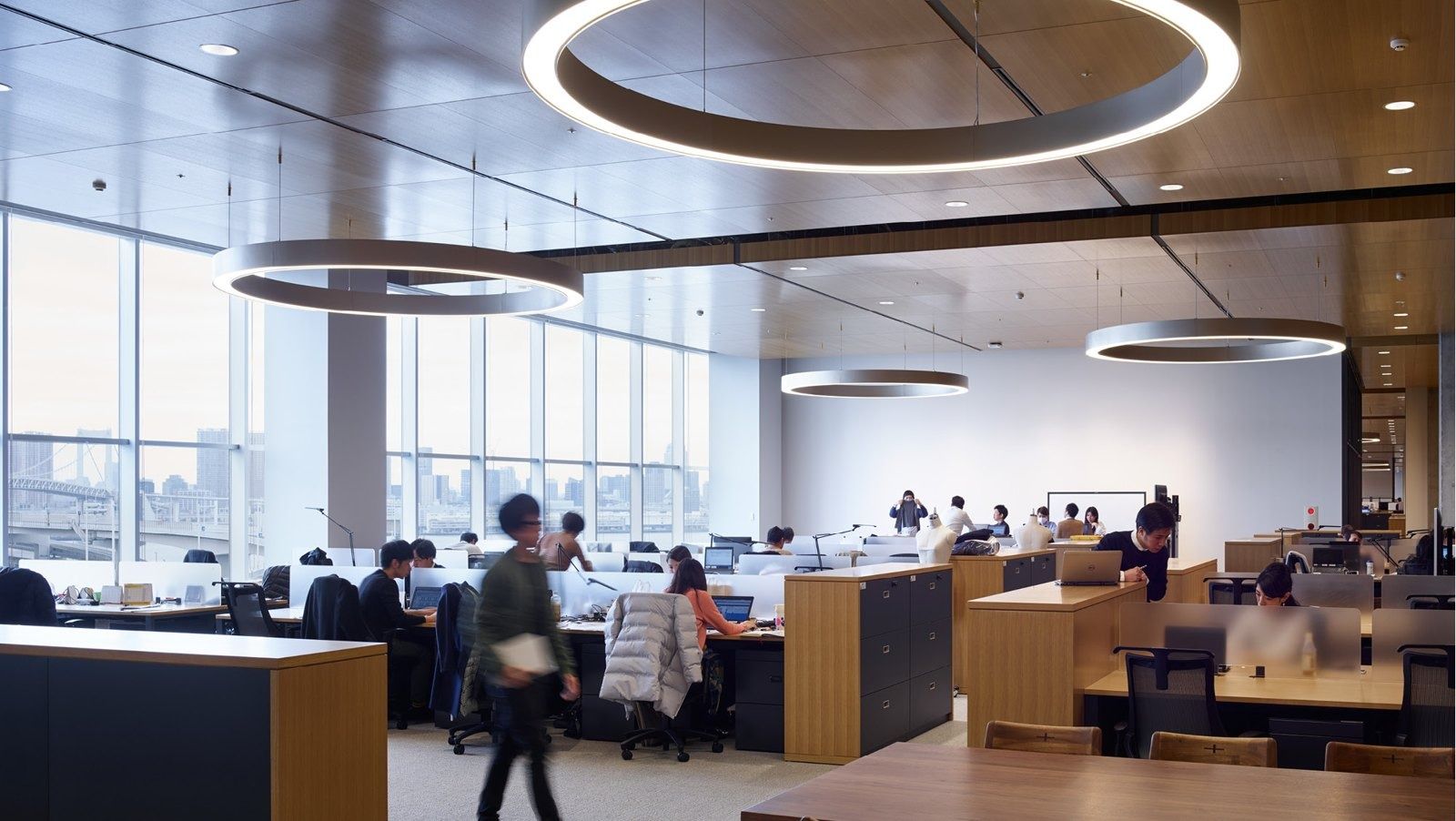 Fast Retailing (UNIQLO): Open desk area under round pendant lights with bay views