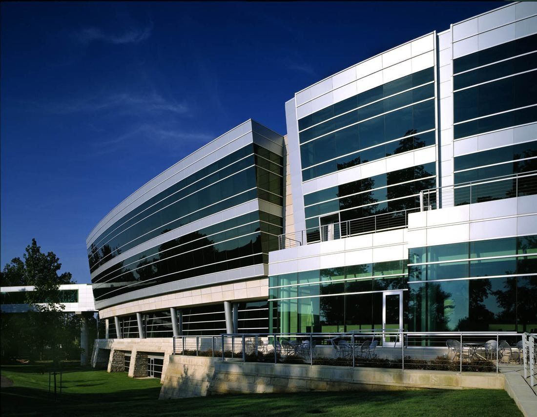 FedEx: Curving building with bands of glass and white metal panels seen from below