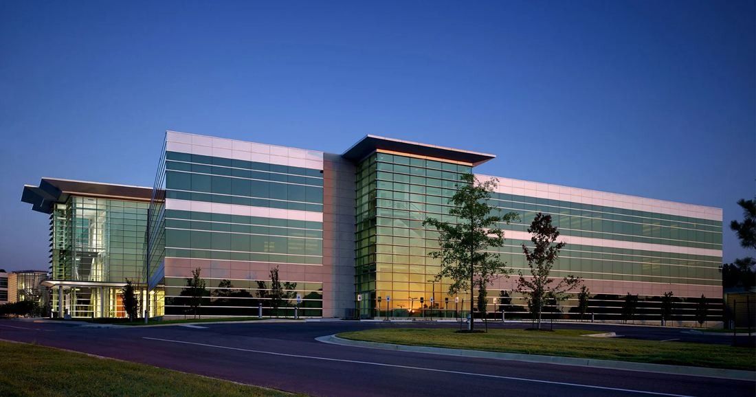 FedEx: Long glass office building reflecting the evening sky across a lawn