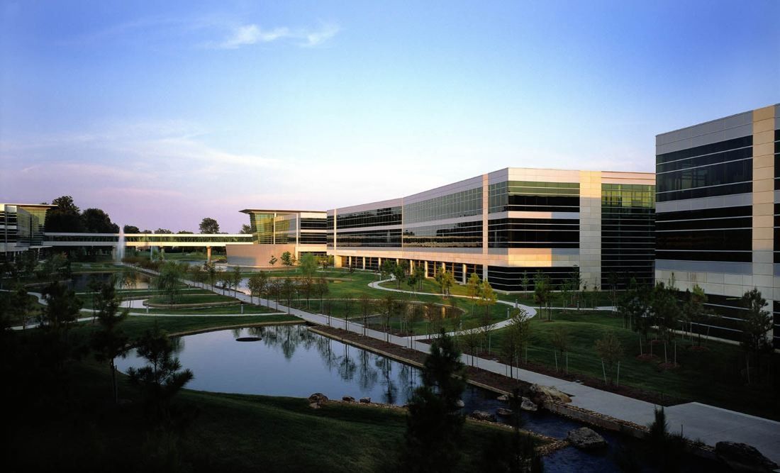 FedEx: Low office buildings around landscaped paths and a reflecting pond at dusk