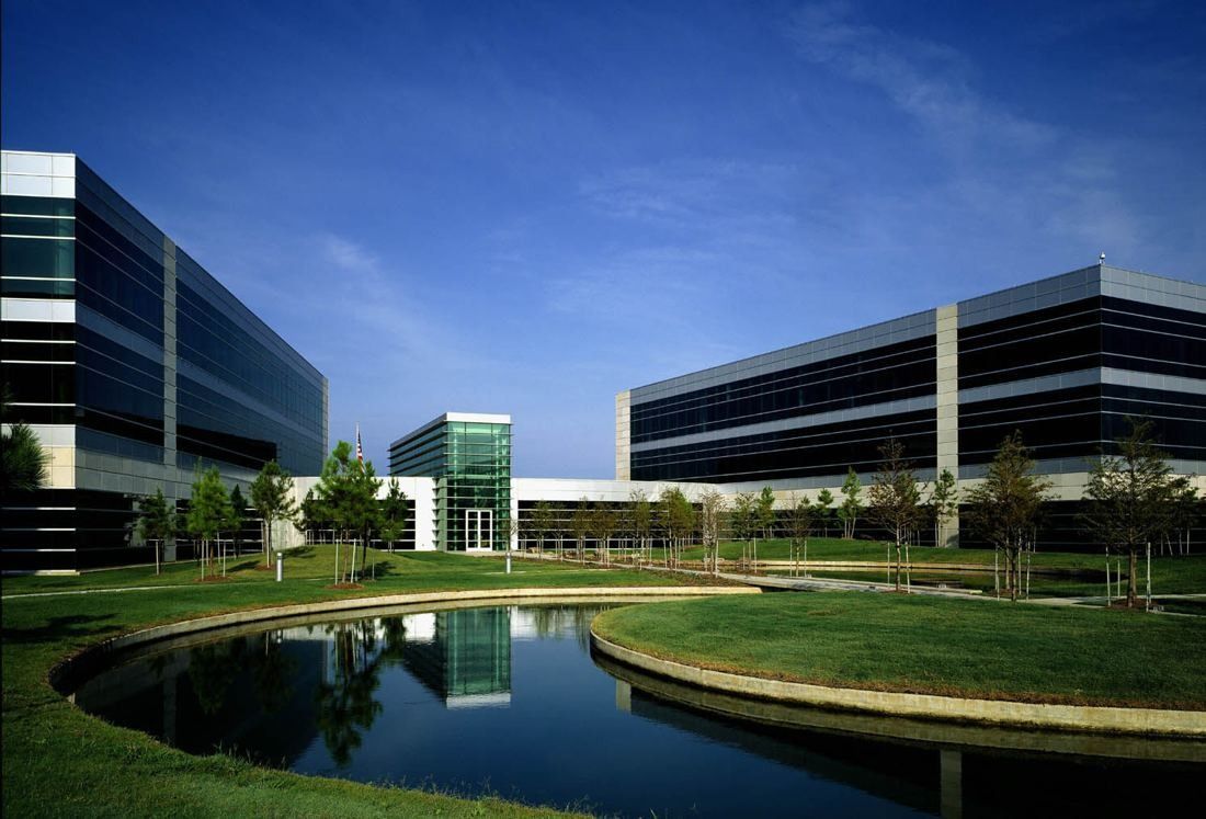 FedEx: Two long glass office buildings beside a curved pond and lawn