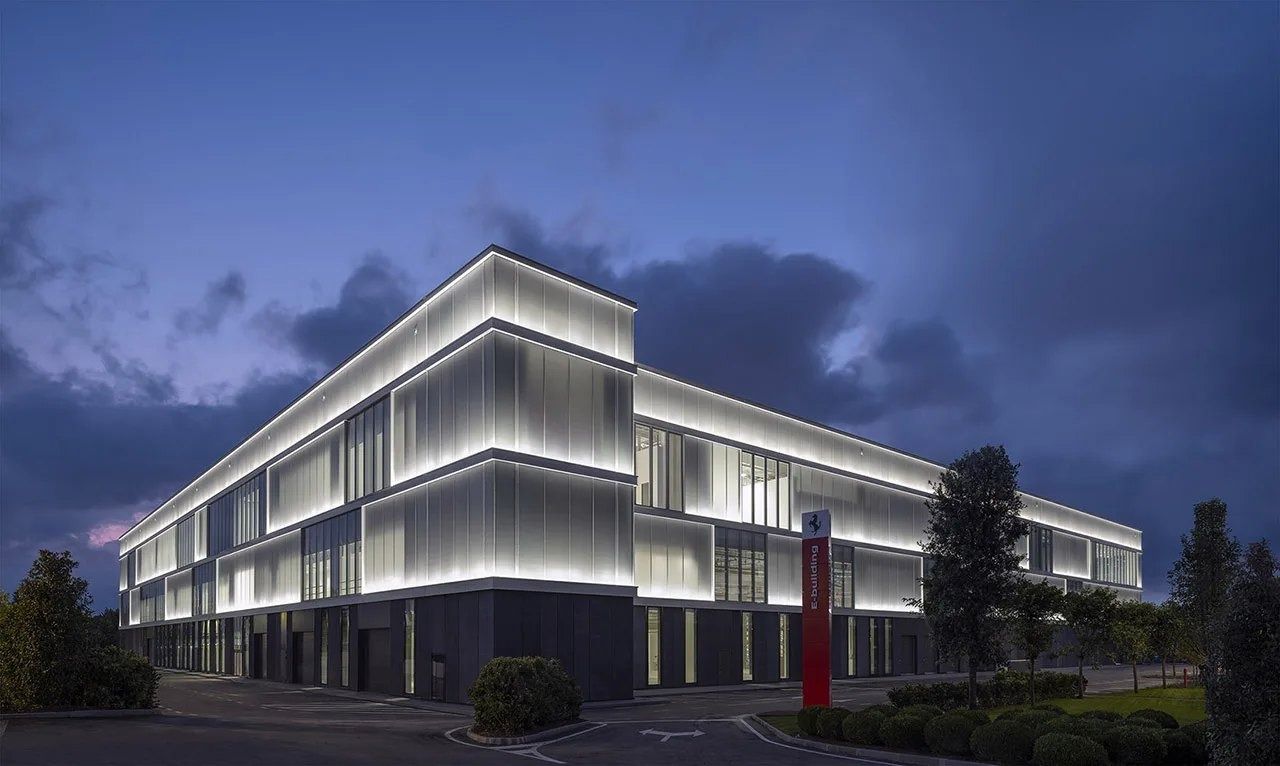 Ferrari: Glowing glass building at dusk