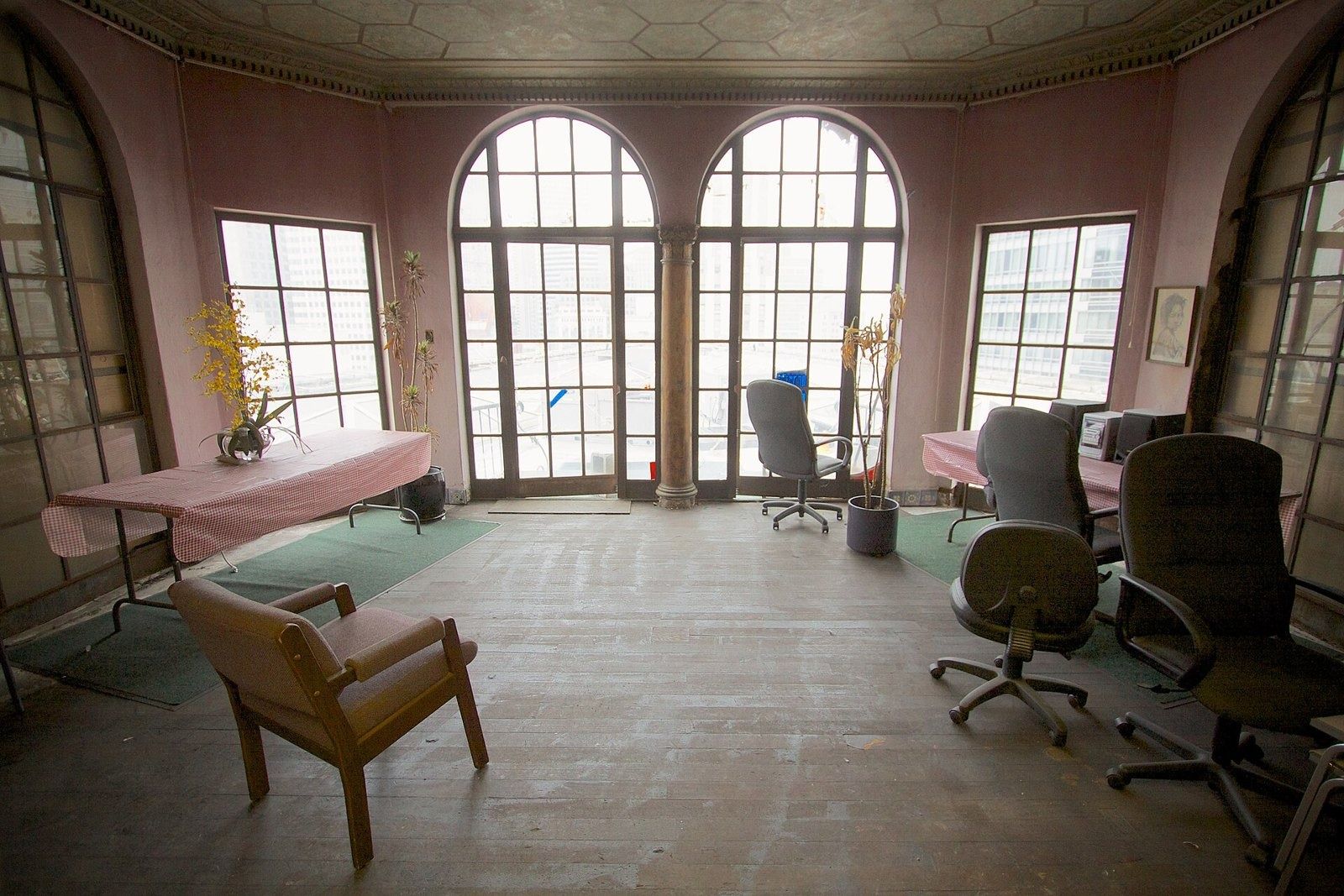 Figma: Empty room with tall arched windows, a few chairs and a small table