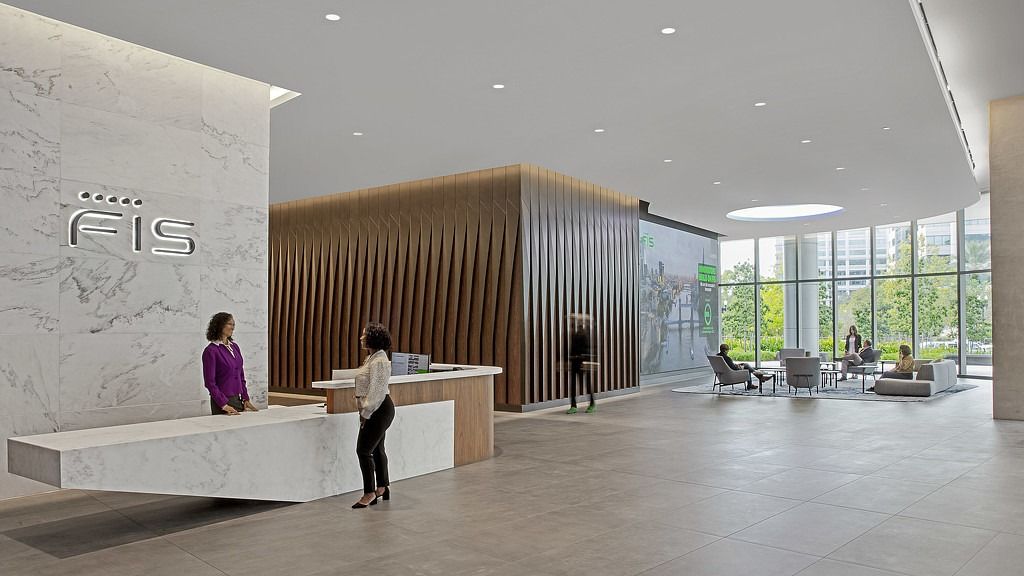 FIS: A bright lobby with a stone reception desk and a big FIS logo wall