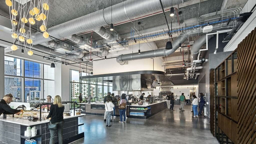 FIS: A busy food hall with counters, hanging lamps and exposed ducts