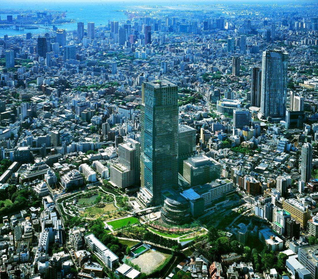 Fujifilm: Aerial view of a tall tower and surrounding buildings and park within a dense city