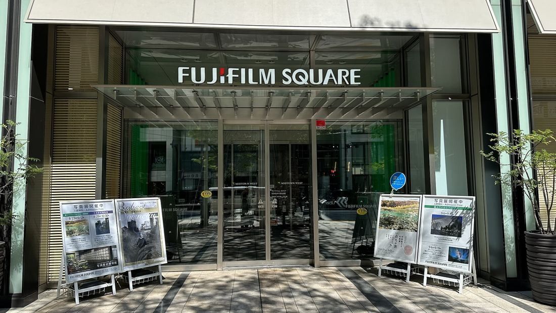 Fujifilm: Entrance doors under a canopy with display boards set out on the pavement