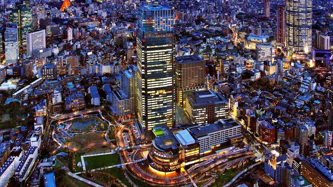 Fujifilm: Night aerial view of a lit tower and low-rise buildings around a park