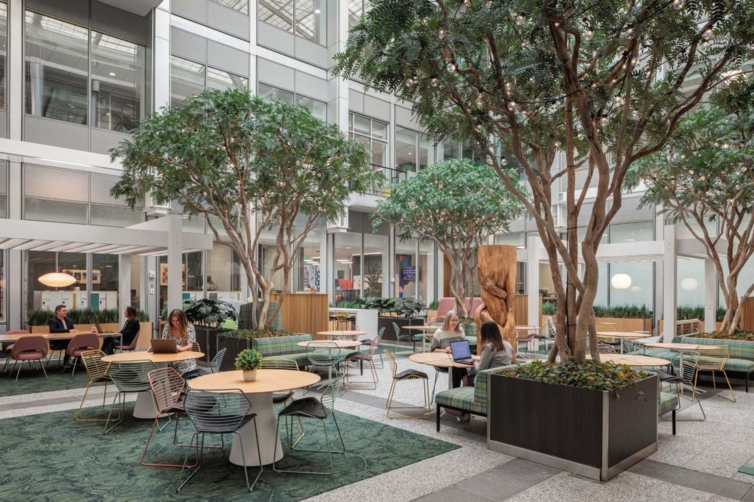 General Mills: Atrium with large indoor trees, round tables and wire chairs