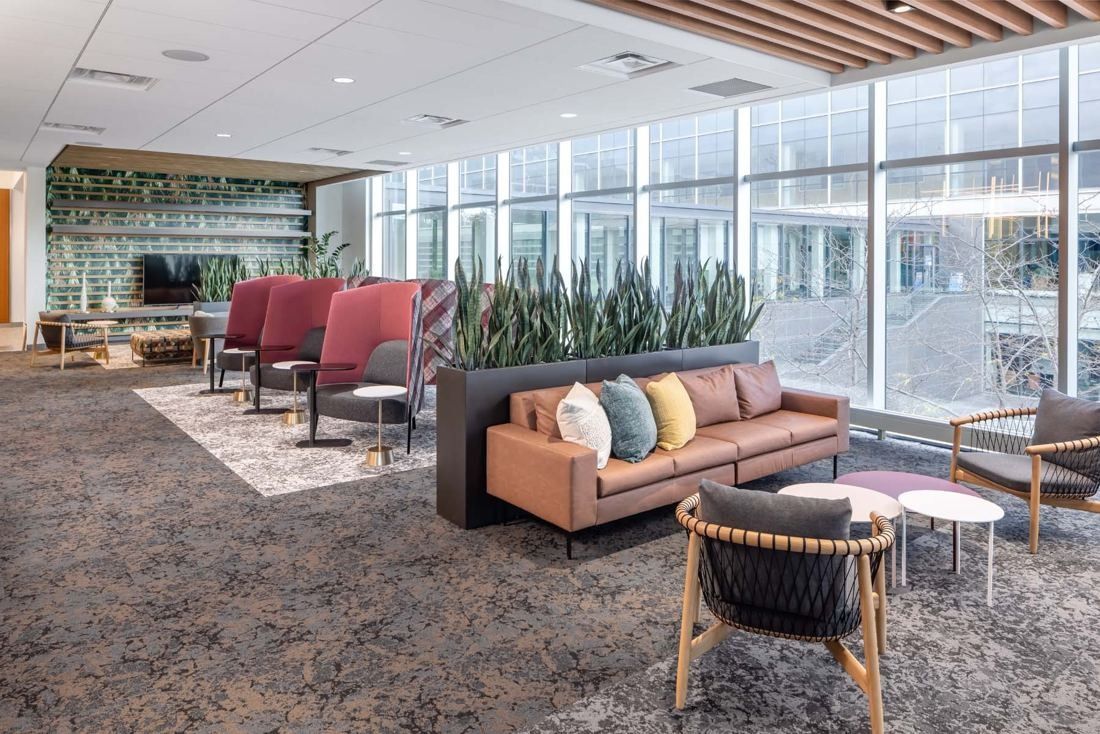 General Mills: Lounge with a leather sofa, high-backed chairs and planters beside a full-height glass wall