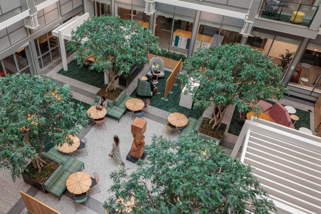 General Mills: View down into an atrium with trees, wooden sculpture and scattered seating