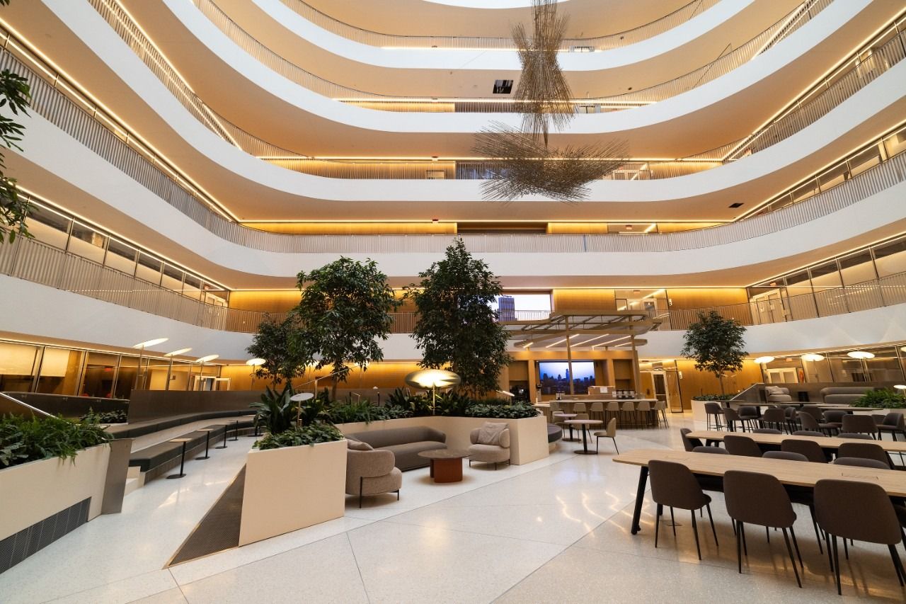 Seven-storey atrium with trees, tables and curved balconies