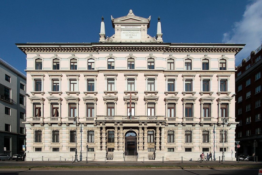 Eclectic limestone palazzo with a pediment and statues on its roofline