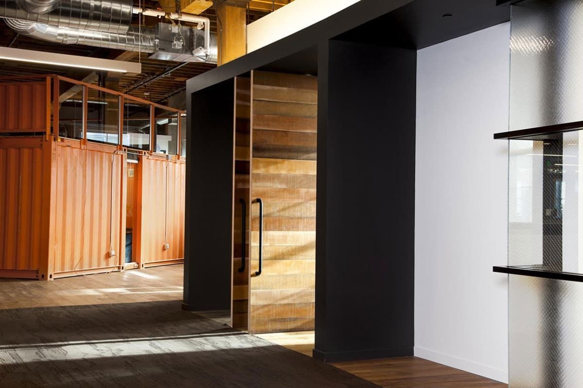 GitHub: Corridor past a room clad in orange shipping-container steel