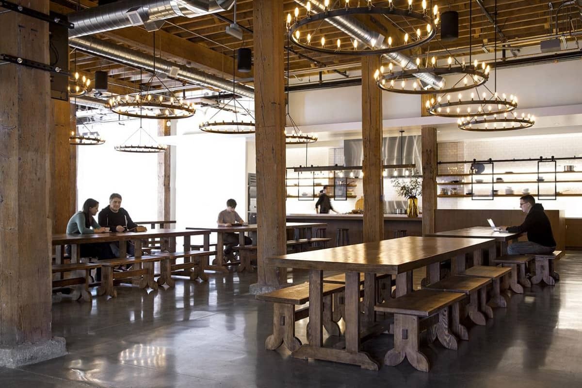 GitHub: Long wooden tables under iron chandeliers