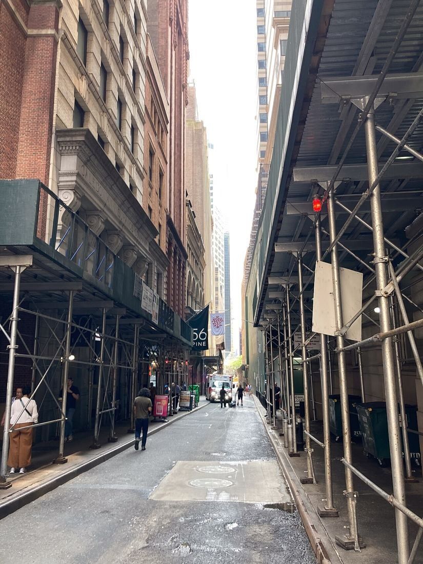 Narrow downtown street lined with tall buildings and scaffolding