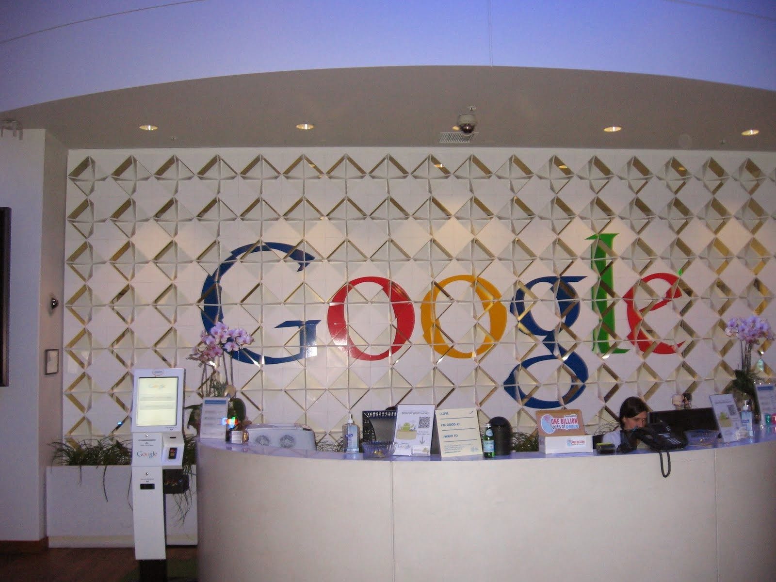 Reception desk in front of a Google logo made of shapes