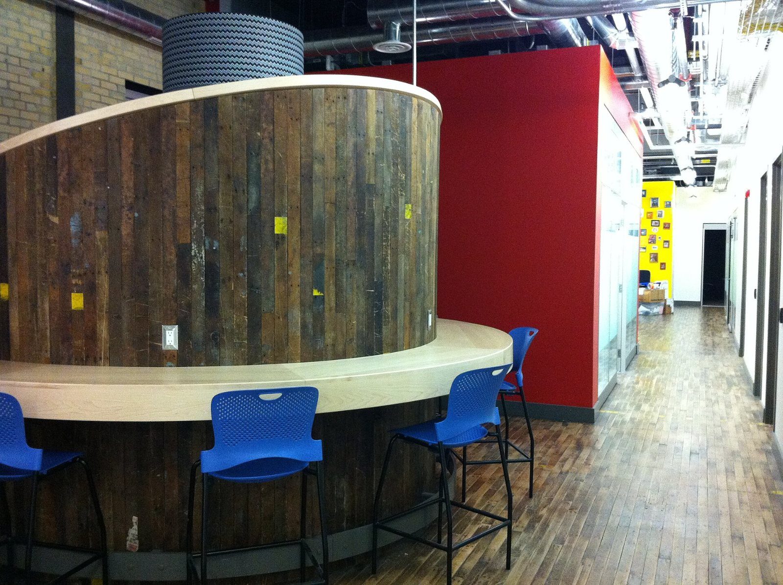 Google: Round wooden booth with blue stools