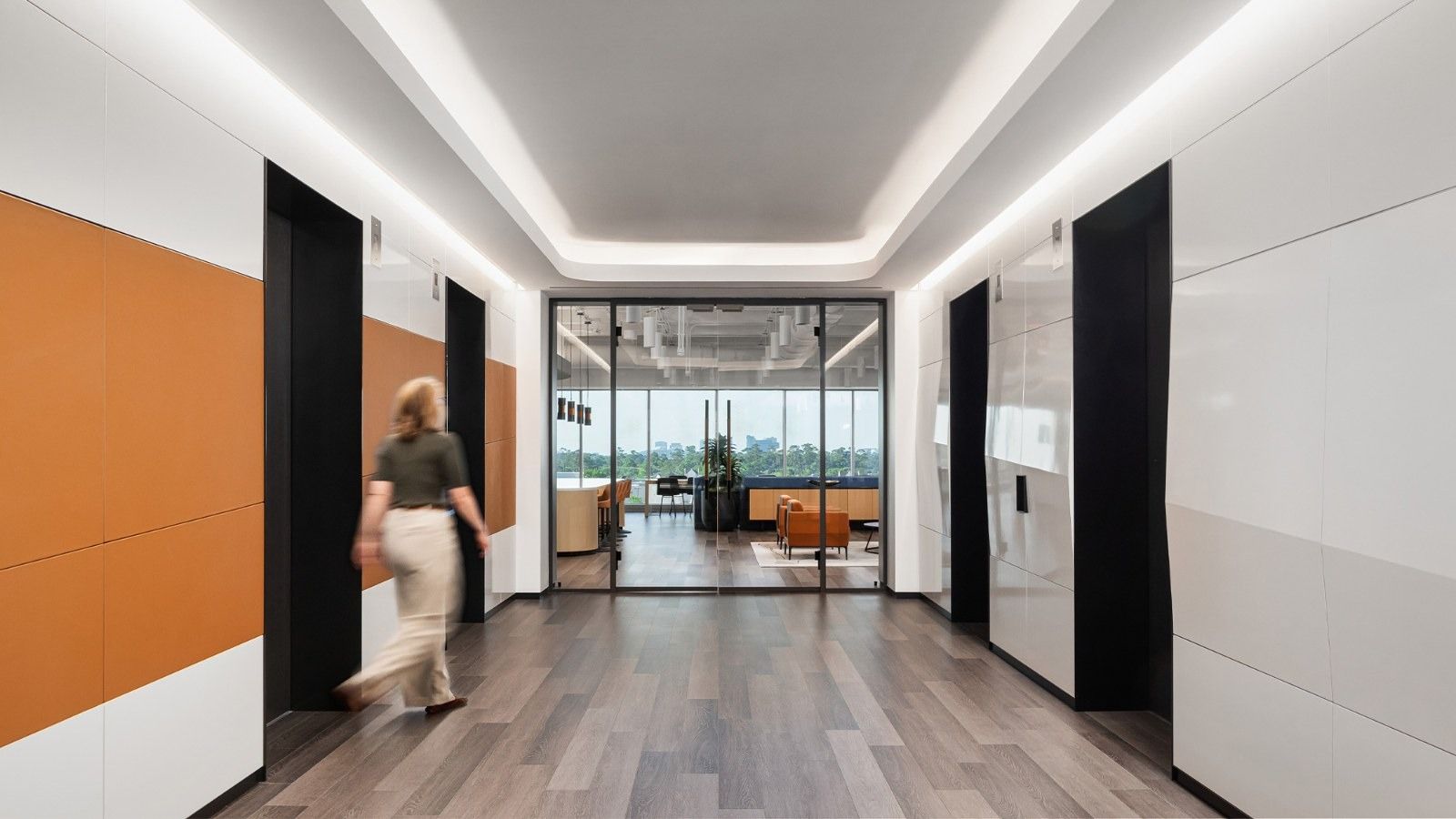 Group 1 Automotive: A corridor with orange and white panels and glass doors