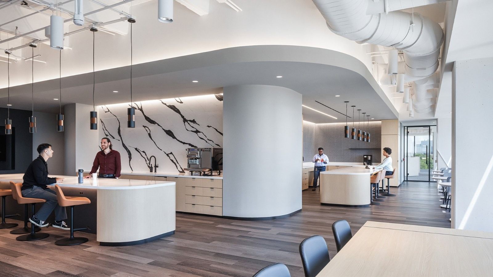 Group 1 Automotive: Curved white counters and a marble-patterned wall under a sweeping ceiling