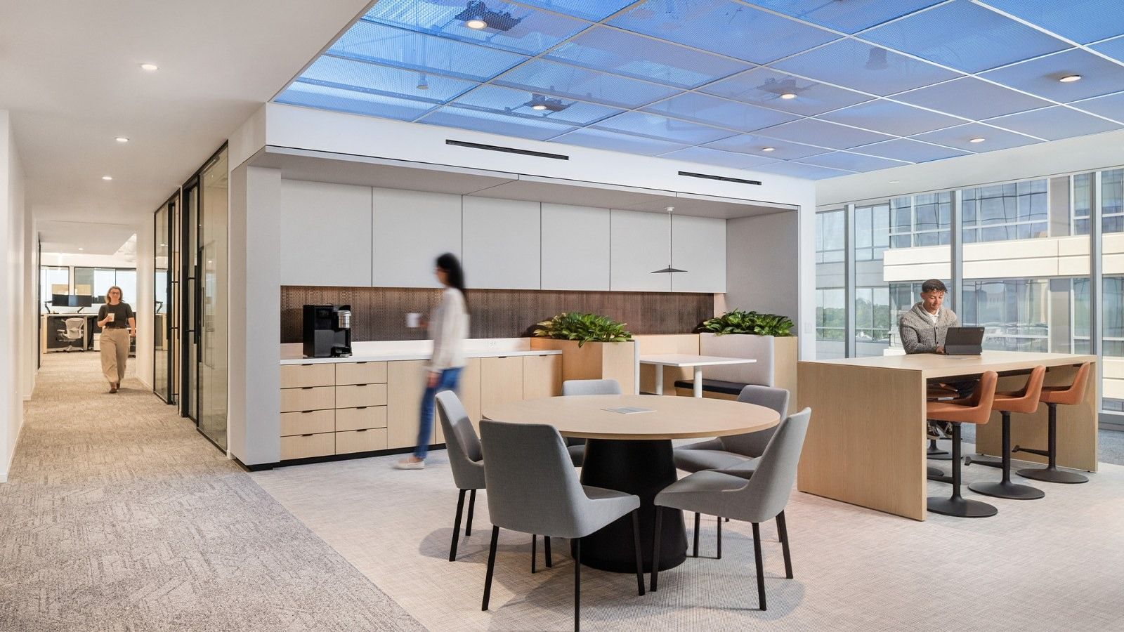 Group 1 Automotive: Round tables and a pantry under a glowing ceiling panel