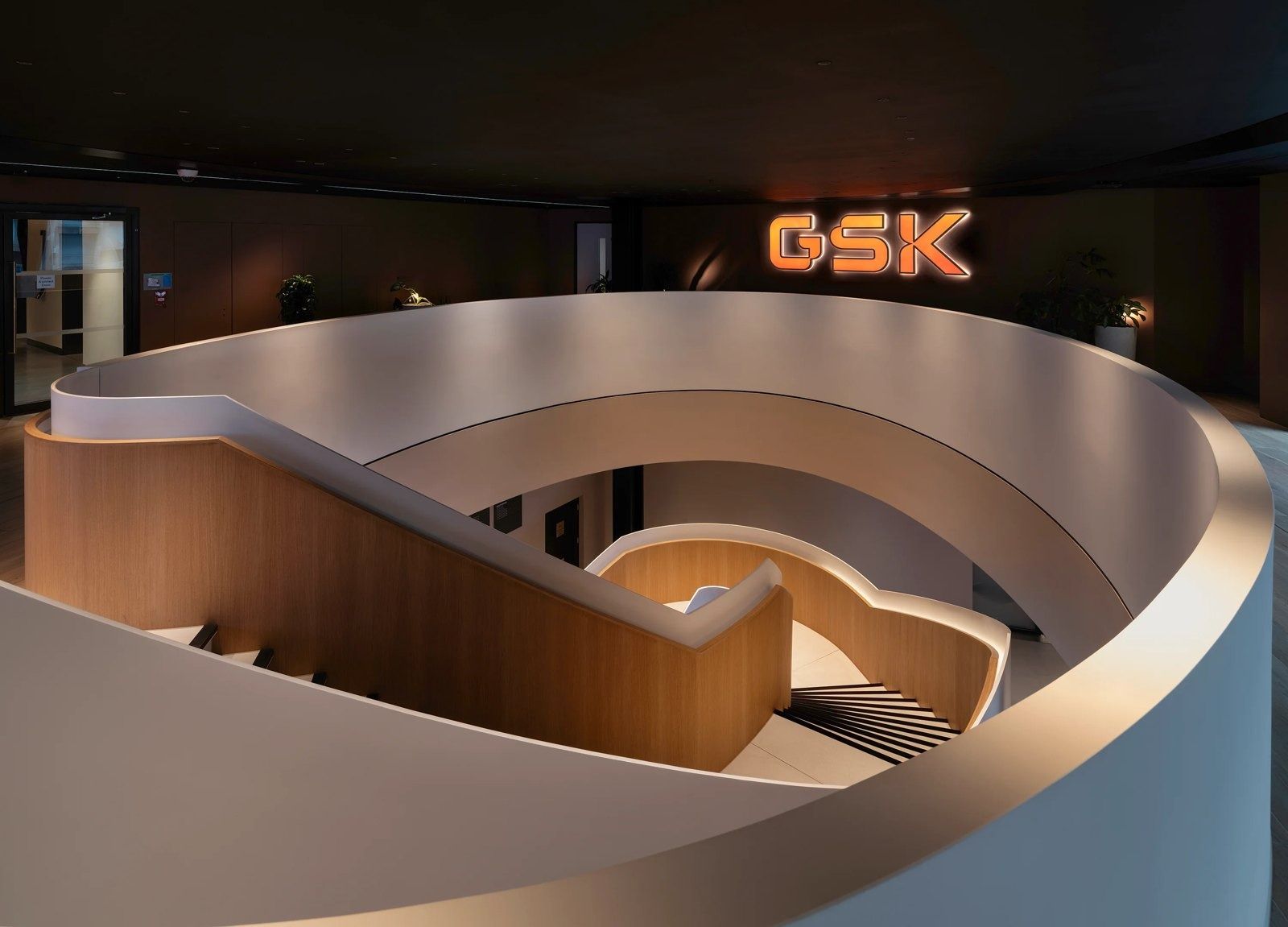 GSK: Curved staircase with an illuminated GSK sign