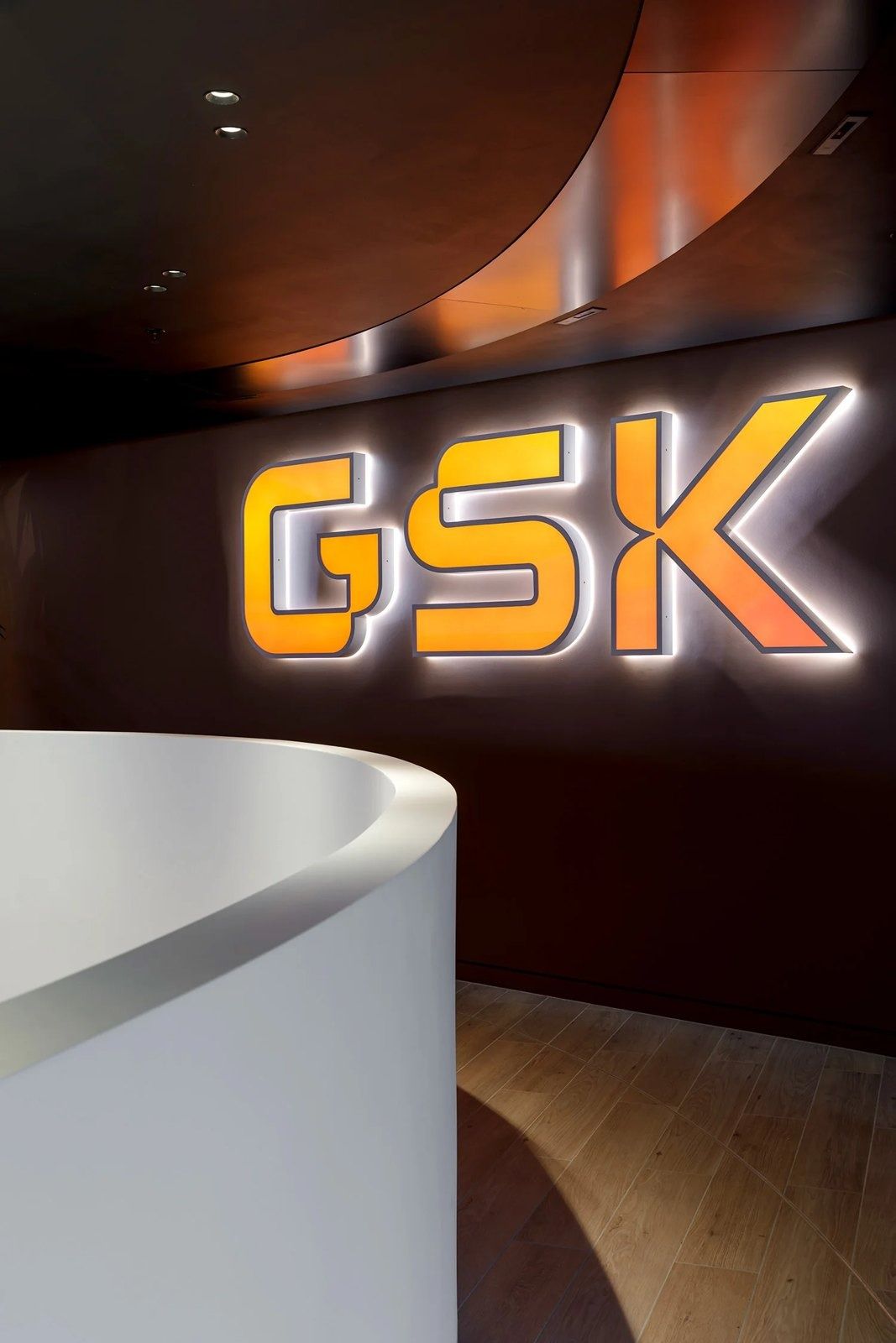 GSK: Glowing GSK sign on a curved wall