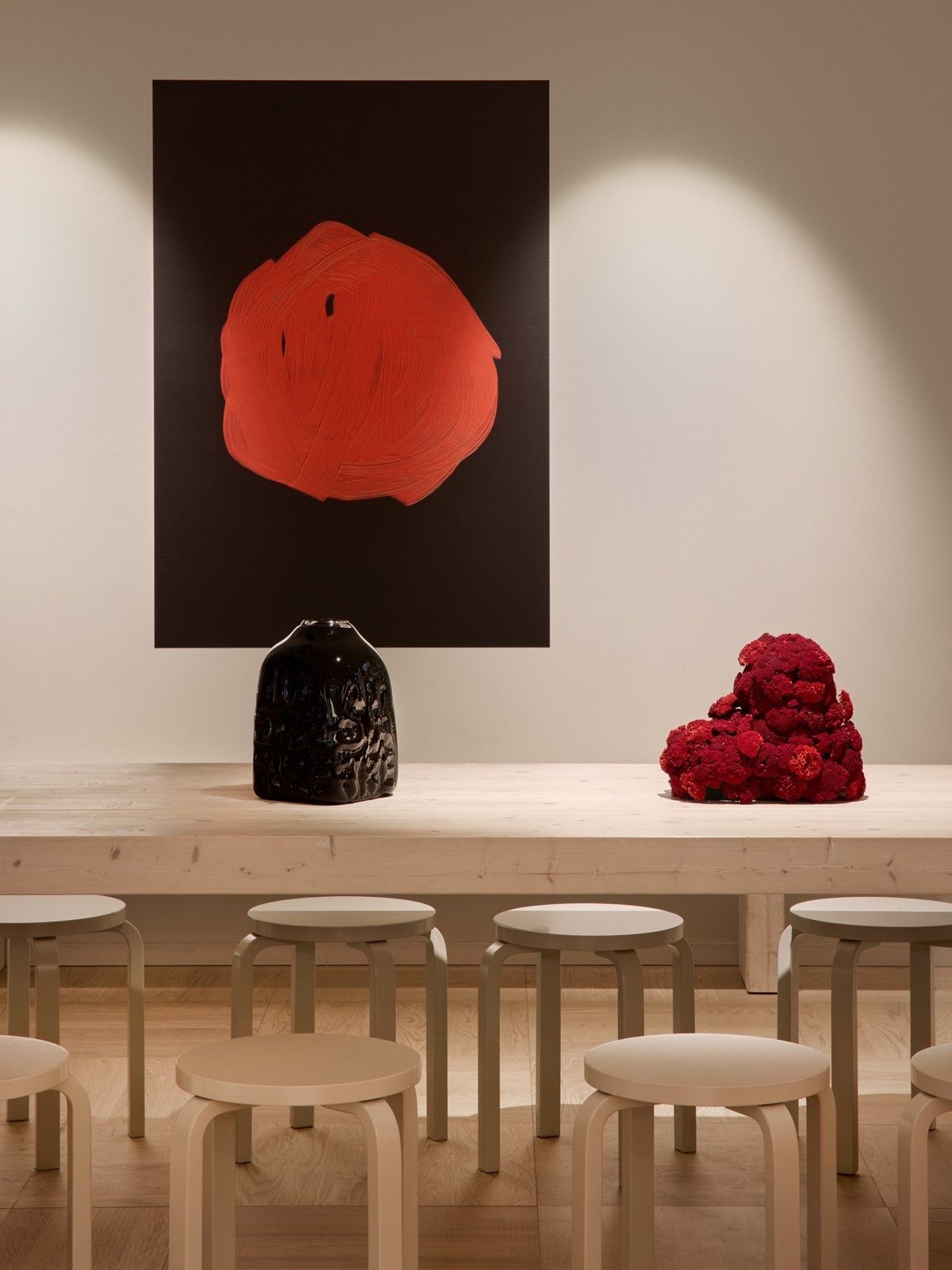 H&M Group: White table with stools and a red artwork