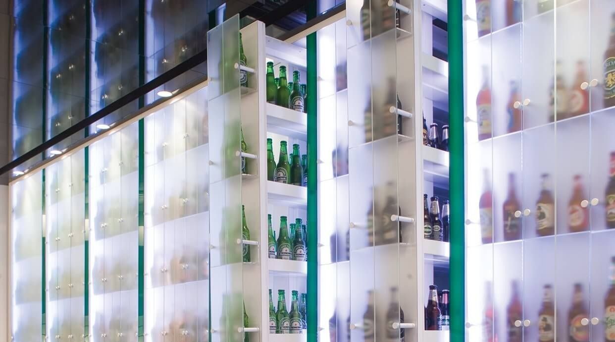 Heineken: Backlit glass shelves displaying rows of beer bottles