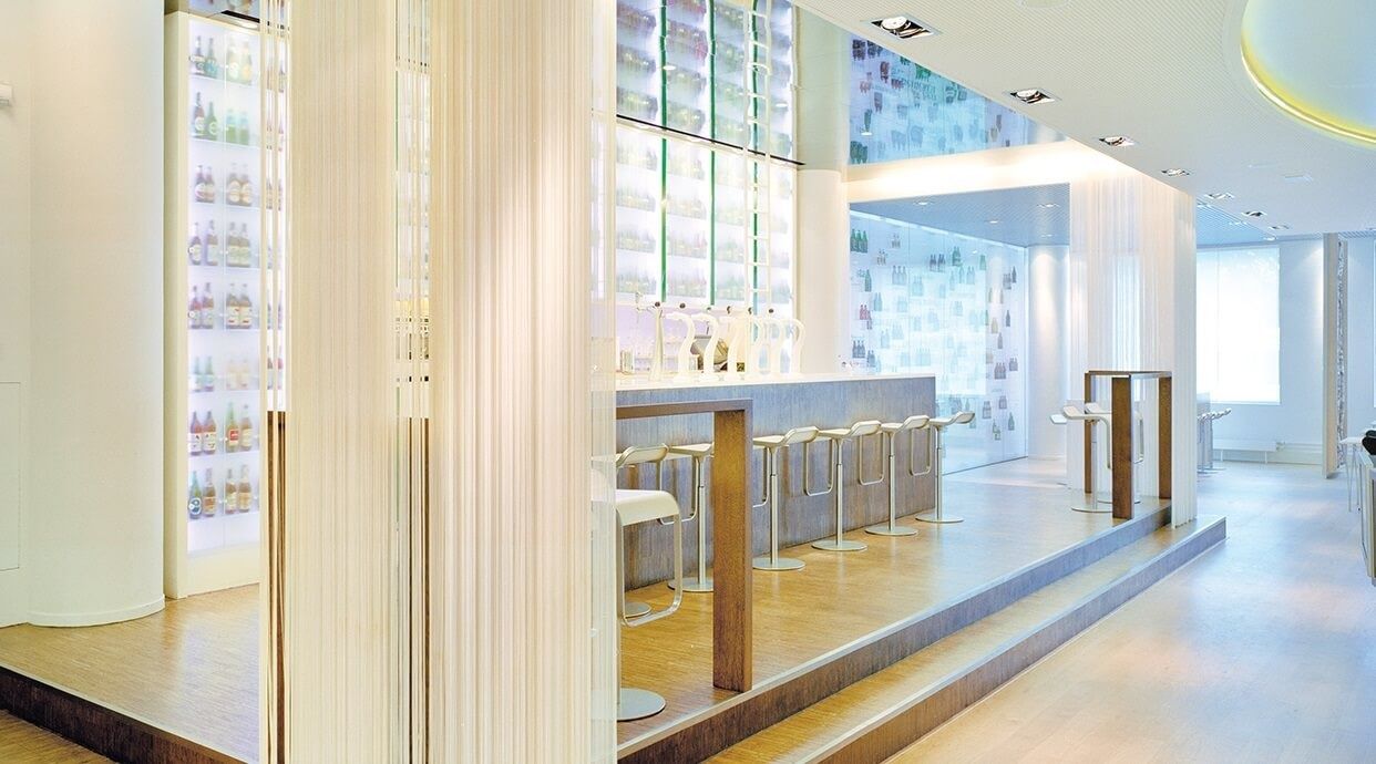 Heineken: Bar counter on a raised wooden floor beside a curtain of white strands and a tiled display wall