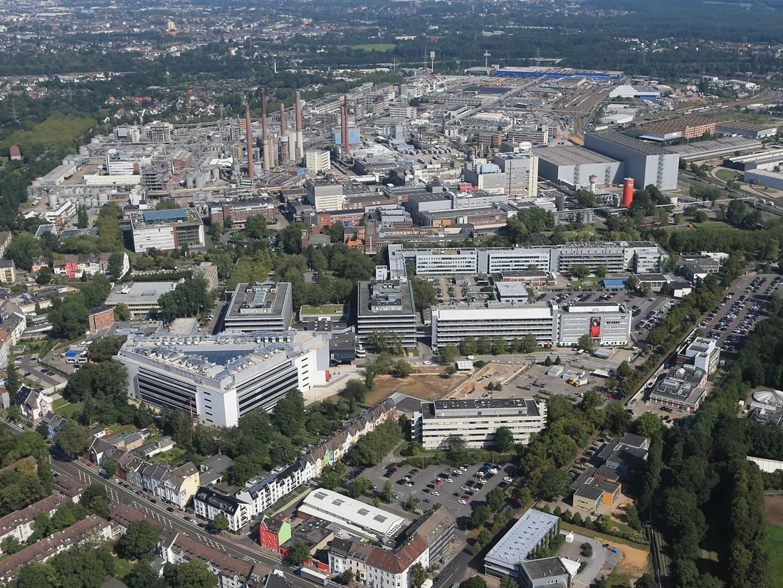 Henkel: Aerial view of a large industrial and office site amid housing and trees