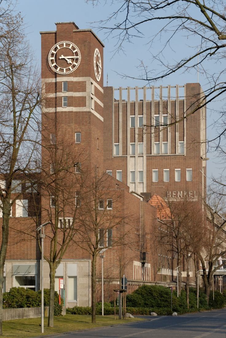 Henkel: Brick tower building with a clock, seen through bare trees