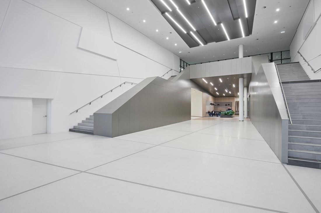 Henkel: Grey stair block in a white hall with strip lighting
