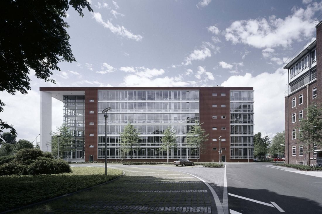 Henkel: Long glazed office facade beside a road and lawn