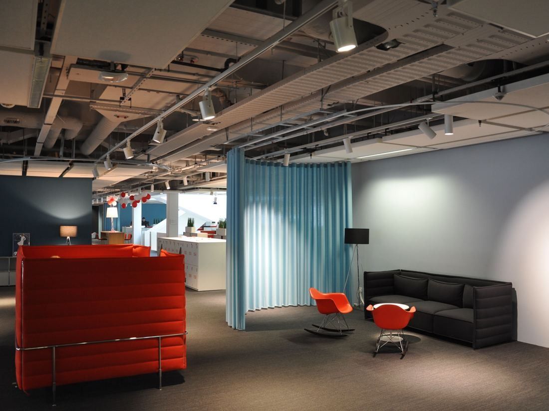 Henkel: Lounge corner with red and black seating and blue curtains