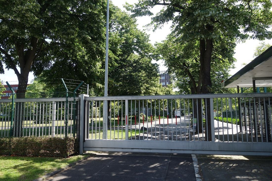 Henkel: Sliding gate under trees at a site entrance