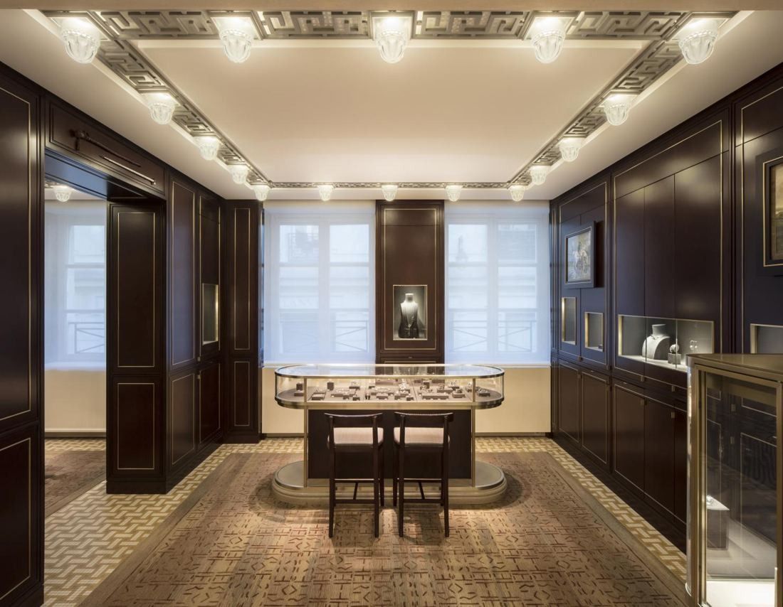 Hermès: Dark wood-panelled room with a central glass display case and tall windows