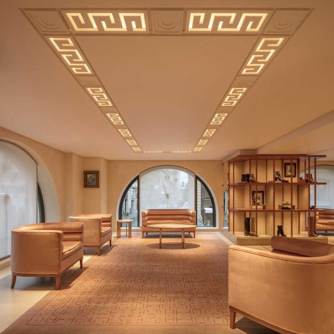 Hermès: Room with leather armchairs, wooden shelving and a patterned ceiling cornice