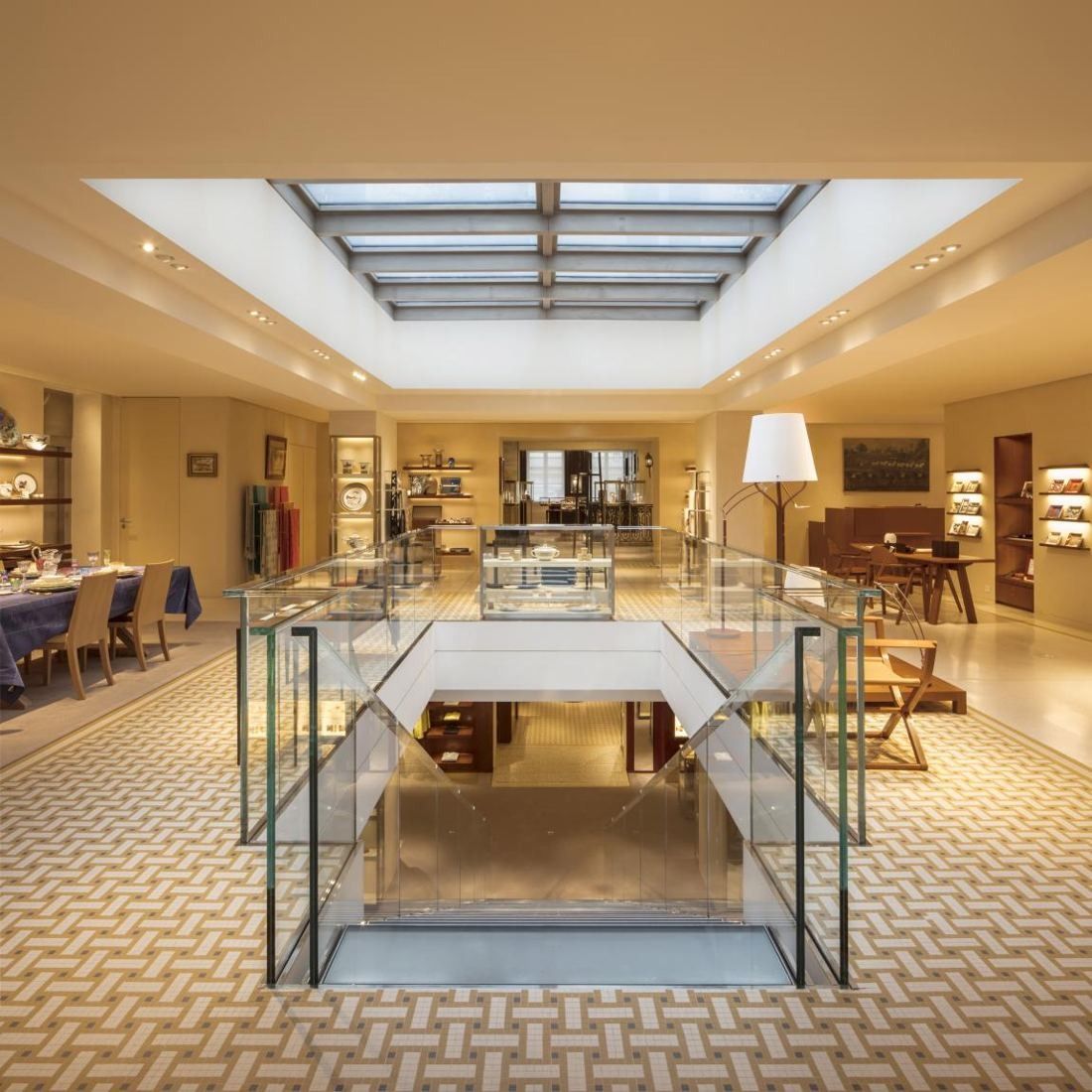 Hermès: Store floor with a skylight, glass balustrade around an opening and a woven-pattern floor