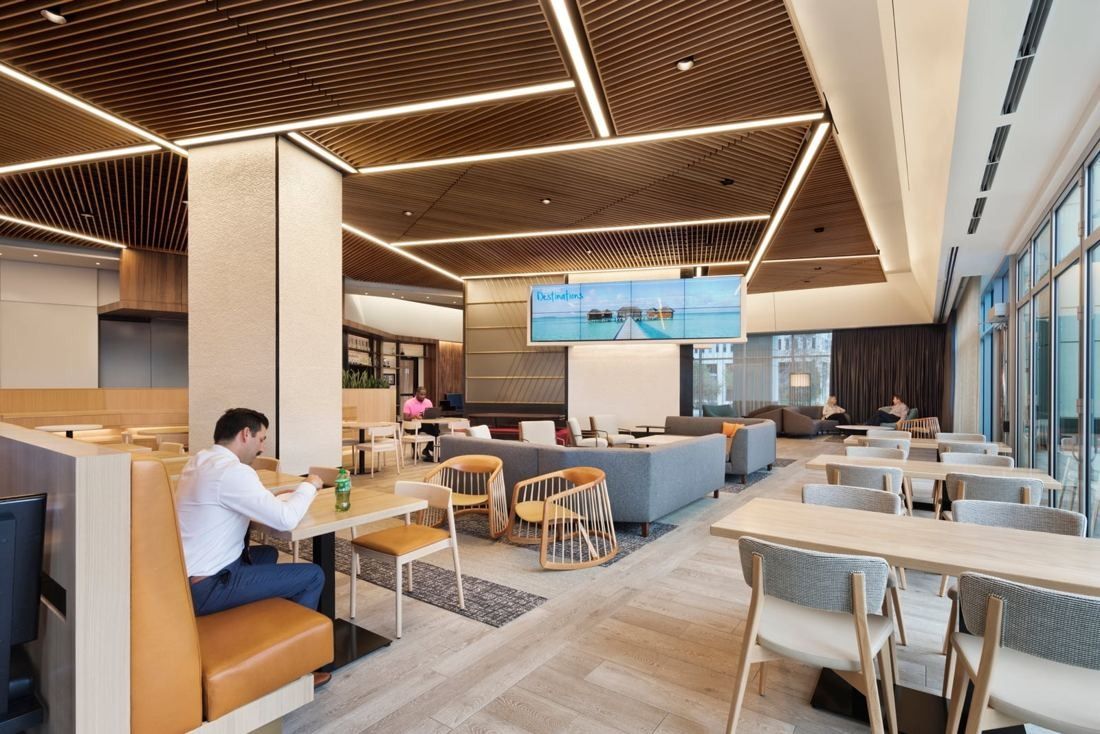 Hilton: Dining and lounge area with slatted wood ceiling, light strips, booths, sofas and a large screen