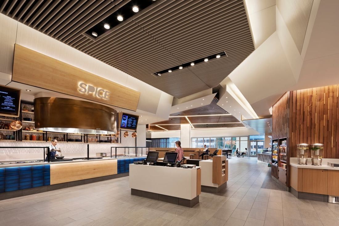 Hilton: Food hall interior with a copper hood over the SPICE station and wood ceiling slats