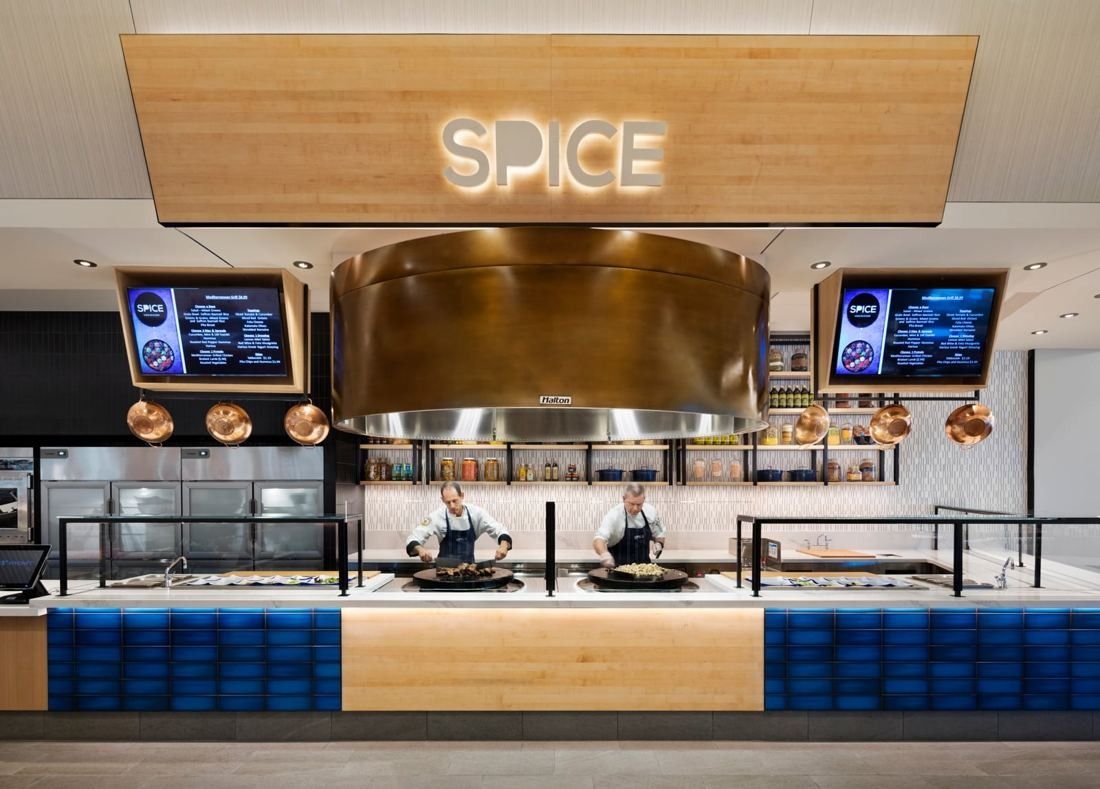 Hilton: Food station under a SPICE sign with a copper hood and blue tiled counter