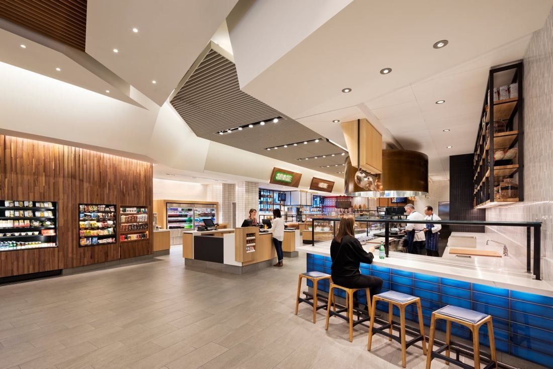 Hilton: Grab-and-go market with wood-lined shelving and a blue counter with stools