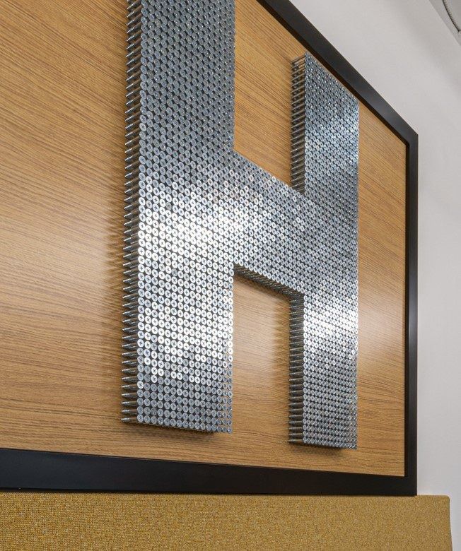 The Home Depot: Large letter H made of metal tools on a wood wall